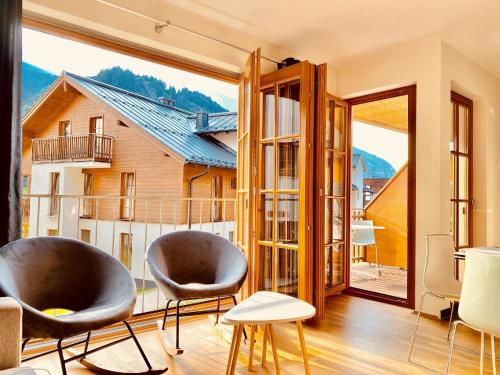 une chambre avec deux chaises et une grande fenêtre dans l'établissement Ferienwohnung für 5 Personen ca 55 qm in Rauris, Salzburger Land Rauristal, à Rauris