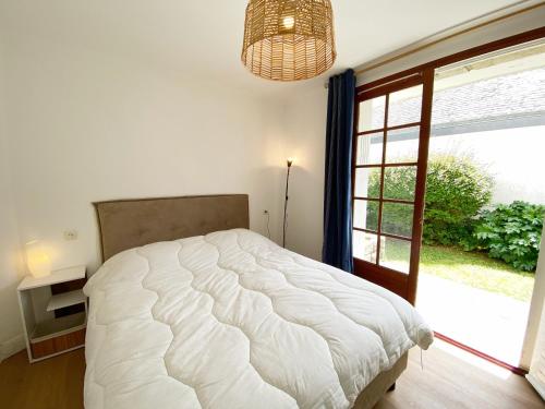 une chambre avec un lit et une grande fenêtre dans l'établissement ARVOR 3 - Rez-de-jardin, Terrasse, Plage - T40, à Carnac