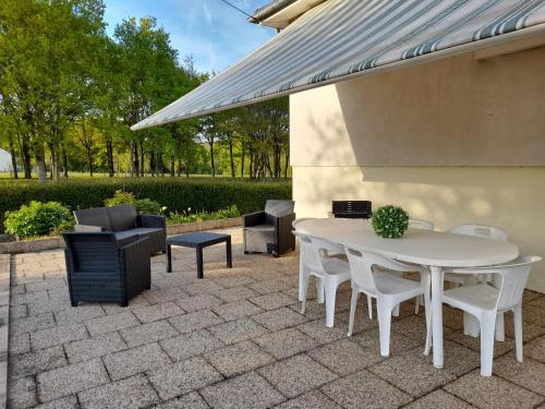 d'une terrasse avec une table et des chaises blanches. dans l'établissement Villa Amazone, à Onzain