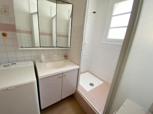 une salle de bain blanche avec un lavabo et un miroir dans l'établissement ARVOR 3 - Rez-de-jardin, Terrasse, Plage - T40, à Carnac