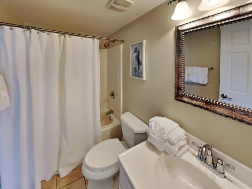 a bathroom with a toilet and a sink and a mirror at Ocean Breeze East #802 in Perdido Key