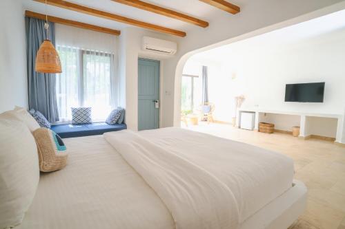 a white bedroom with a large bed and a tv at Kassandra Boutique Hotel in Oludeniz