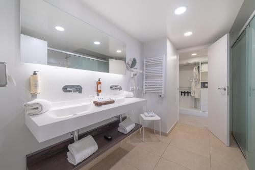 uma casa de banho branca com um lavatório e um chuveiro em Hotel Boutique Minister 4Sup em Port de Sóller