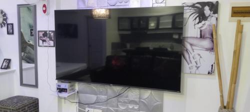 a flat screen tv hanging on a wall at Jack Kandi Grosvenor Square in Angeles
