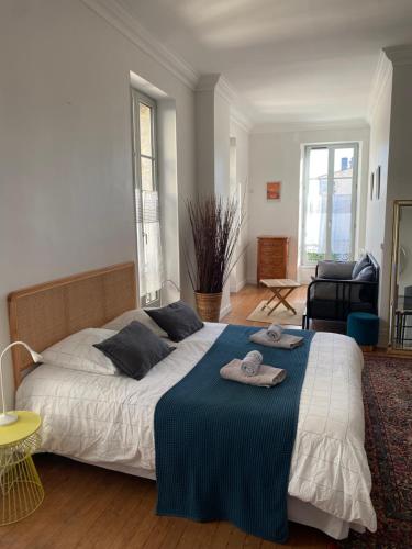 sypialnia z dużym łóżkiem i niebieskim kocem w obiekcie Maison St Romain Blaye w mieście Blaye