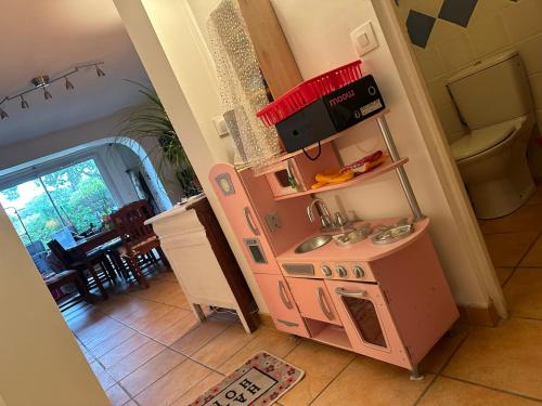 a small pink kitchen with a sink in a room at Plage des Salins Parc des Salins St Tropez in Saint-Tropez