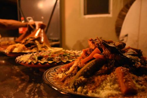 two plates of food on a table with pizzas at Playa Del Sol Surf House in Tamraght Ouzdar