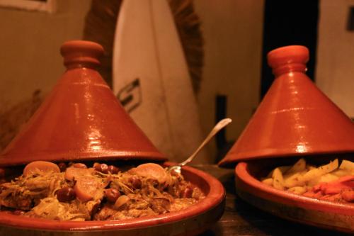 two red bowls of food on a table at Playa Del Sol Surf House in Tamraght Ouzdar