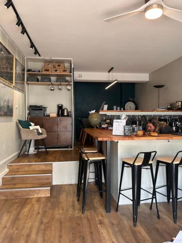 uma cozinha com um balcão com bancos e uma mesa em Vacances à la Mer la Turballe Ajonc em La Turballe