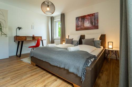 a bedroom with a large bed and a desk at dreamcation - Ehemaliges Pfarrhaus, 3D-Tour, 4 SZ, Terrasse, BBQ, Küche, Garten, 140qm in Kelheim