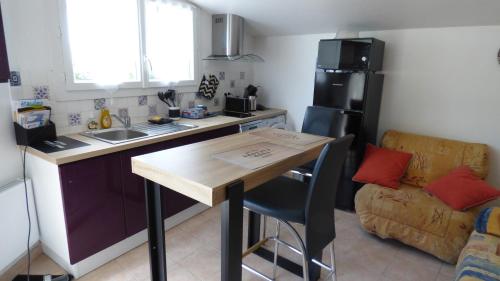 Il comprend une cuisine équipée d'une table et d'un réfrigérateur. dans l'établissement Studio Rénové entre Royan et Oléron, à Étaules