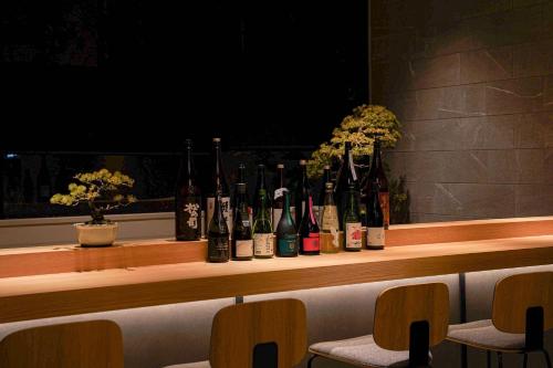 uma fila de garrafas de vinho sentadas num balcão em Nico Hotel em Osaka