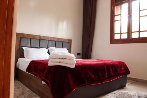 1 dormitorio con 1 cama con manta roja y almohadas blancas en Royal mirage villa(families only), en Marrakech
