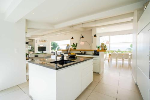 une cuisine blanche avec un évier et un comptoir dans l'établissement Villa Paradiso Luxe, à Cannes