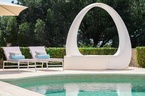 une piscine avec deux chaises à côté d'un miroir dans l'établissement Villa Paradiso Luxe, à Cannes