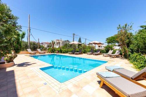 a swimming pool with chaise lounge chairs next to at Villa Armonia Chania in Kato Galatas