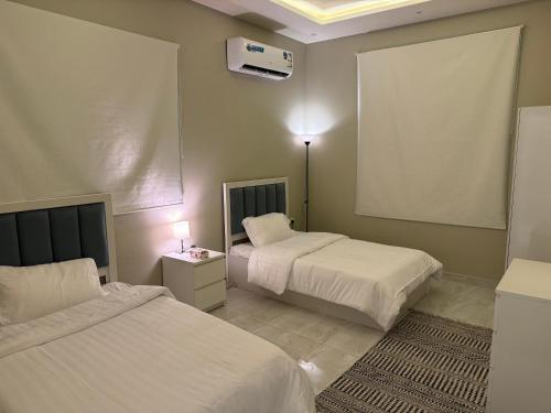 Cette chambre dispose de deux lits et de la climatisation. dans l'établissement Elegant Apartment in Al-Narjis شقة أنيقة بثلاث غرف وصالة تسجيل ذاتي, à Riyad
