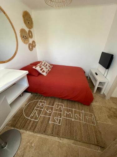 um quarto com uma cama vermelha e um espelho em Entre les Alpilles et le Luberon 3 chambres 10 pers em Cavaillon