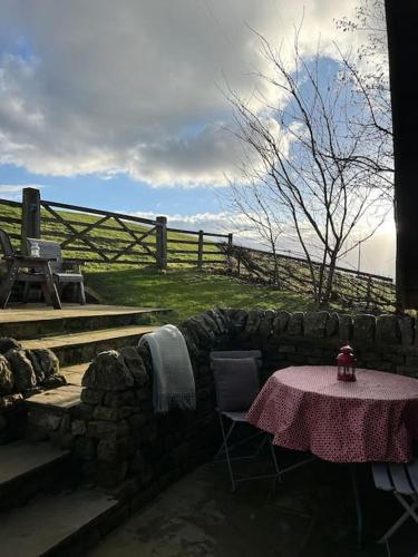 a table and chairs with a table and a fence at Springhill Studio, Brimham Rocks Yorkshire Dales in Grantley