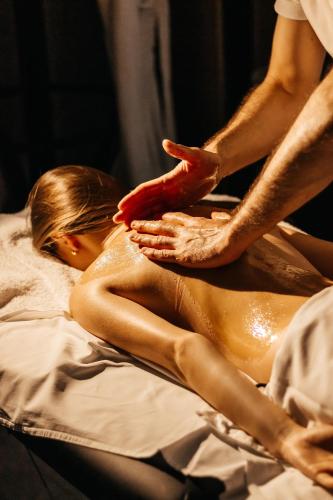 a woman laying on a bed while getting a massage at Rest&Ski Spa Resort in Bukovel