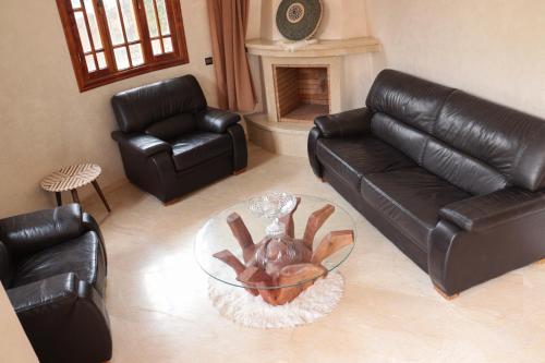 sala de estar con sofá de cuero y mesa de cristal en Royal mirage villa(families only), en Marrakech