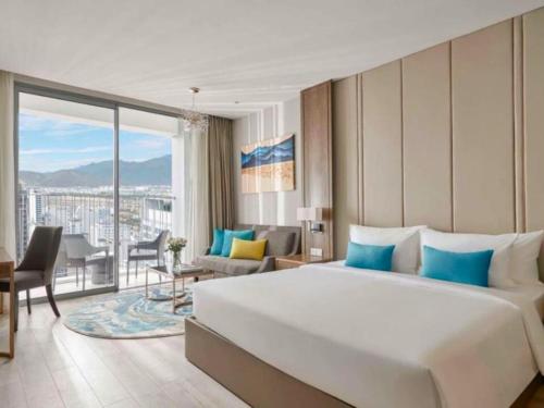 a bedroom with a large bed and a living room at Panorama San Condotel in Nha Trang