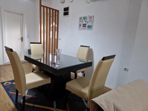 a dining room with a table and chairs and a bed at Town Square House in Gevgelija