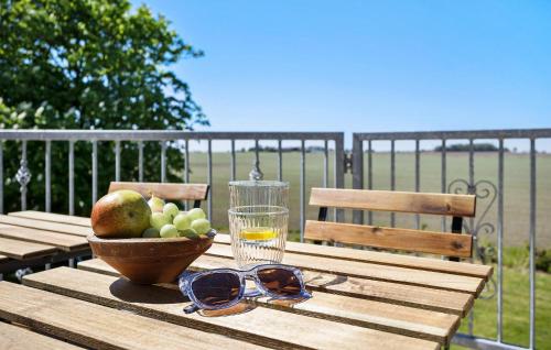 a wooden table with a bowl of fruit and a glass at 6 Bedroom Stunning Home In Højer in Højer