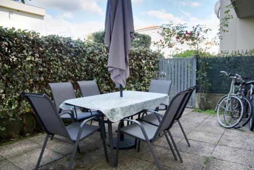 un tavolo e sedie con ombrellone su un patio di Casa Vittoria a Pietrasanta