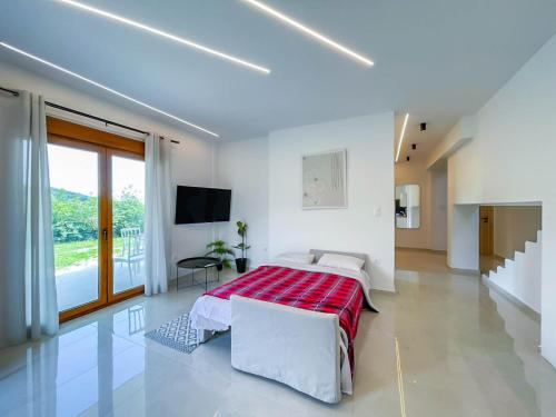 a white bedroom with a bed and a tv at Oasis Acropolis Serres Next to Center in Serres
