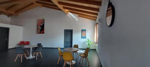 una habitación con mesas y sillas en una habitación con una pared en Affittacamere Arogante di Simona, en Ploaghe