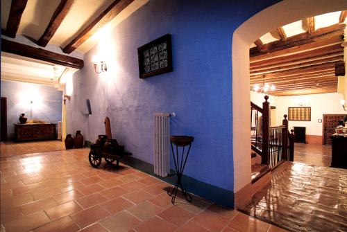 a room with a blue wall with a piano on it at Hospederia Meson de la Dolores in Calatayud