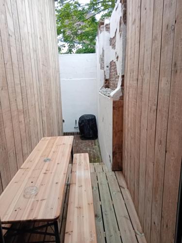 a wooden bench sitting in the corner of a room at Le huit Gite dans villa Aultoise in Ault
