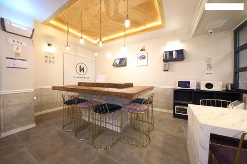 a kitchen with a counter with stools around it at Heimish Hotel in Tongyeong