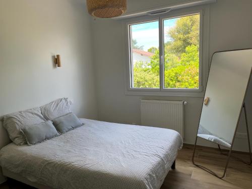 une chambre avec un lit et une fenêtre dans l'établissement Maison avec piscine à SEIGNOSSE 8 personnes, à Seignosse