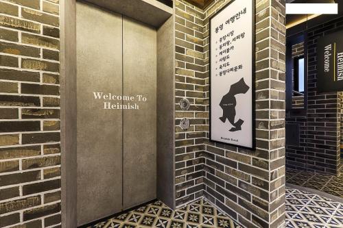 a sign on the side of a brick building at Heimish Hotel in Tongyeong