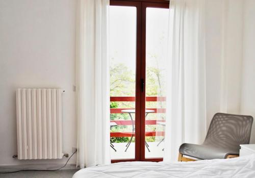 a bedroom with a bed and a chair and a window at Piumahouse B&B in Catanzaro