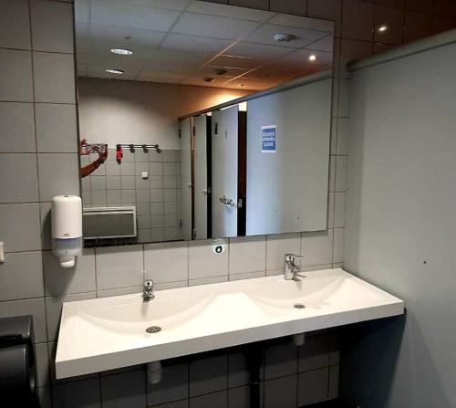 łazienka z umywalką i dużym lustrem w obiekcie Bateau le Zimon - logement insolite w Rouen