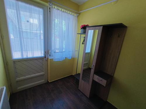 a room with a door and a window and a mirror at AMRI Apartman in Balatonföldvár