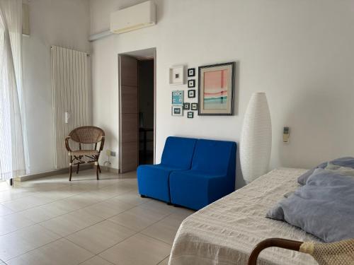 um quarto com um sofá azul e uma cadeira em Peschici a un passo em Peschici