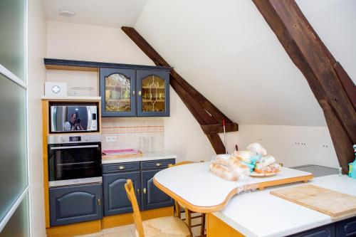 a kitchen with blue cabinets and a white table at Grand gîte de caractère à la campagne in Fercé