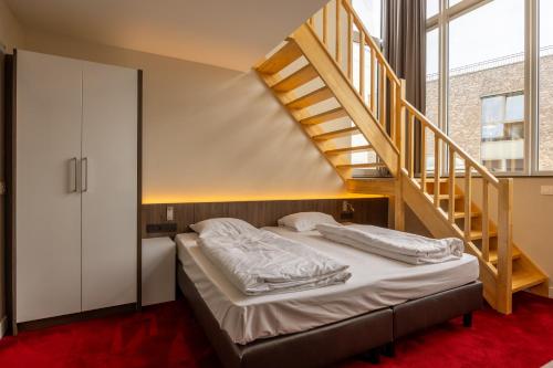 a bedroom with a bed and a staircase at Hotel De Boskar Pelt in Overpelt