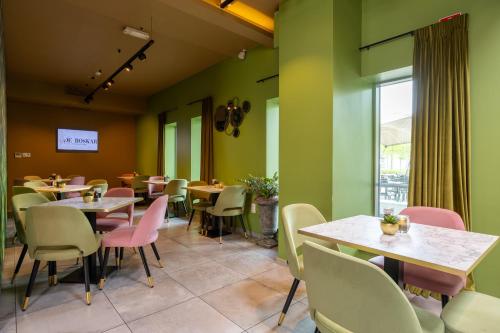 a restaurant with tables and chairs and a window at Hotel De Boskar Pelt in Pelt