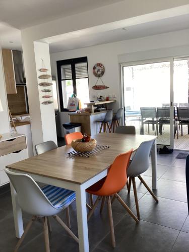 une cuisine et une salle à manger avec une table et des chaises en bois dans l'établissement Villa Chemakhi 10 personnes, à Narbonne