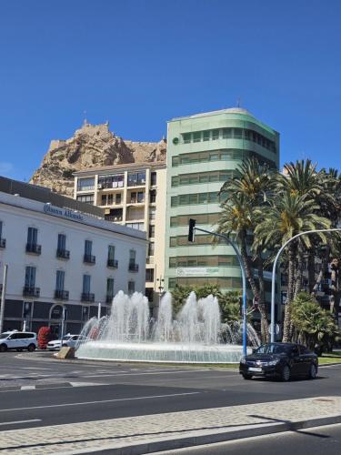 a car driving down a street next to a fountain at Apartamentos Turísticos KENZAMIN in Alicante