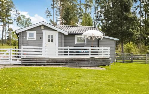 ein kleines Haus mit einem weißen Zaun im Hof in der Unterkunft Lovely Home In Hammarö With Lake View in Hammarö