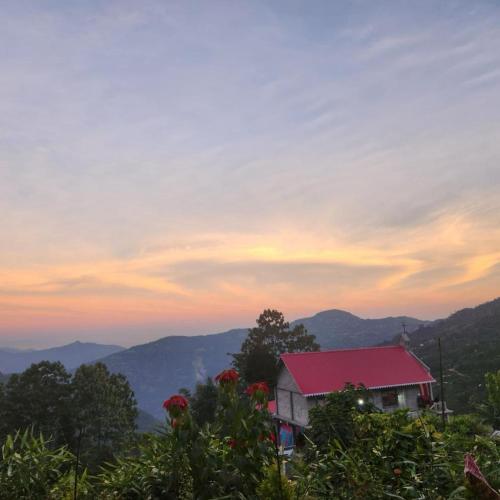 a house with a red roof sitting on top of a hill at Khee Homestay in Kurseong