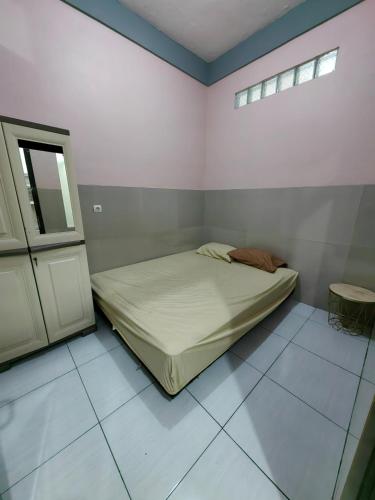 a small bedroom with a bed and a window at Pondok Syariah Hadikusuma in Rahayu