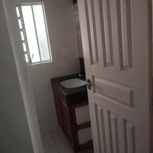 a bathroom with a sink and a window and a door at Sítio São João in Pedro Leopoldo