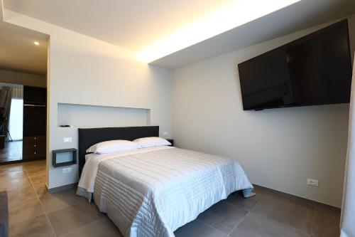 a bedroom with a bed and a flat screen tv at Casa Tua in Formigine